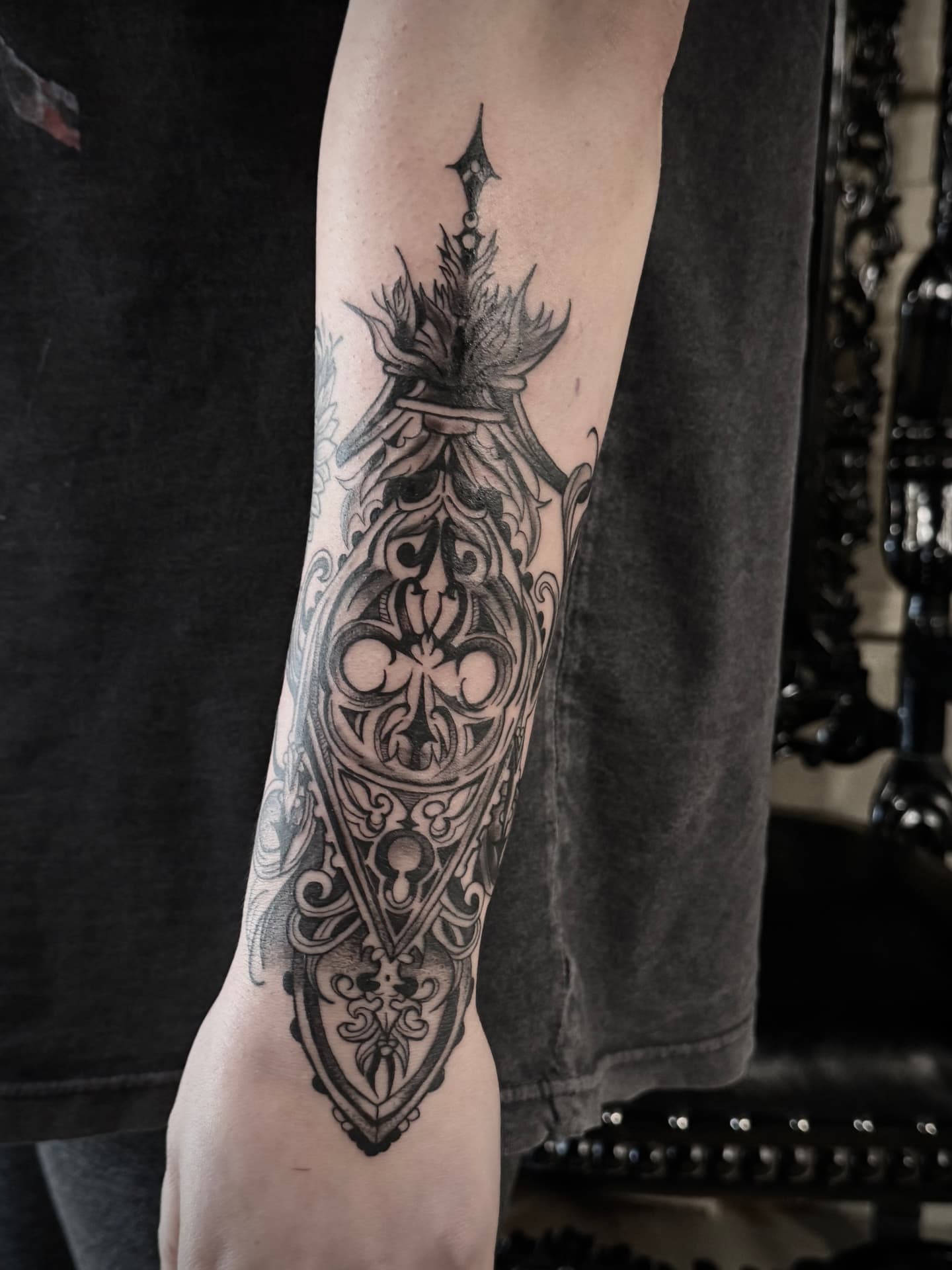 Ornamental blackwork forearm piece with gothic tracery, keyhole and quatrefoil
