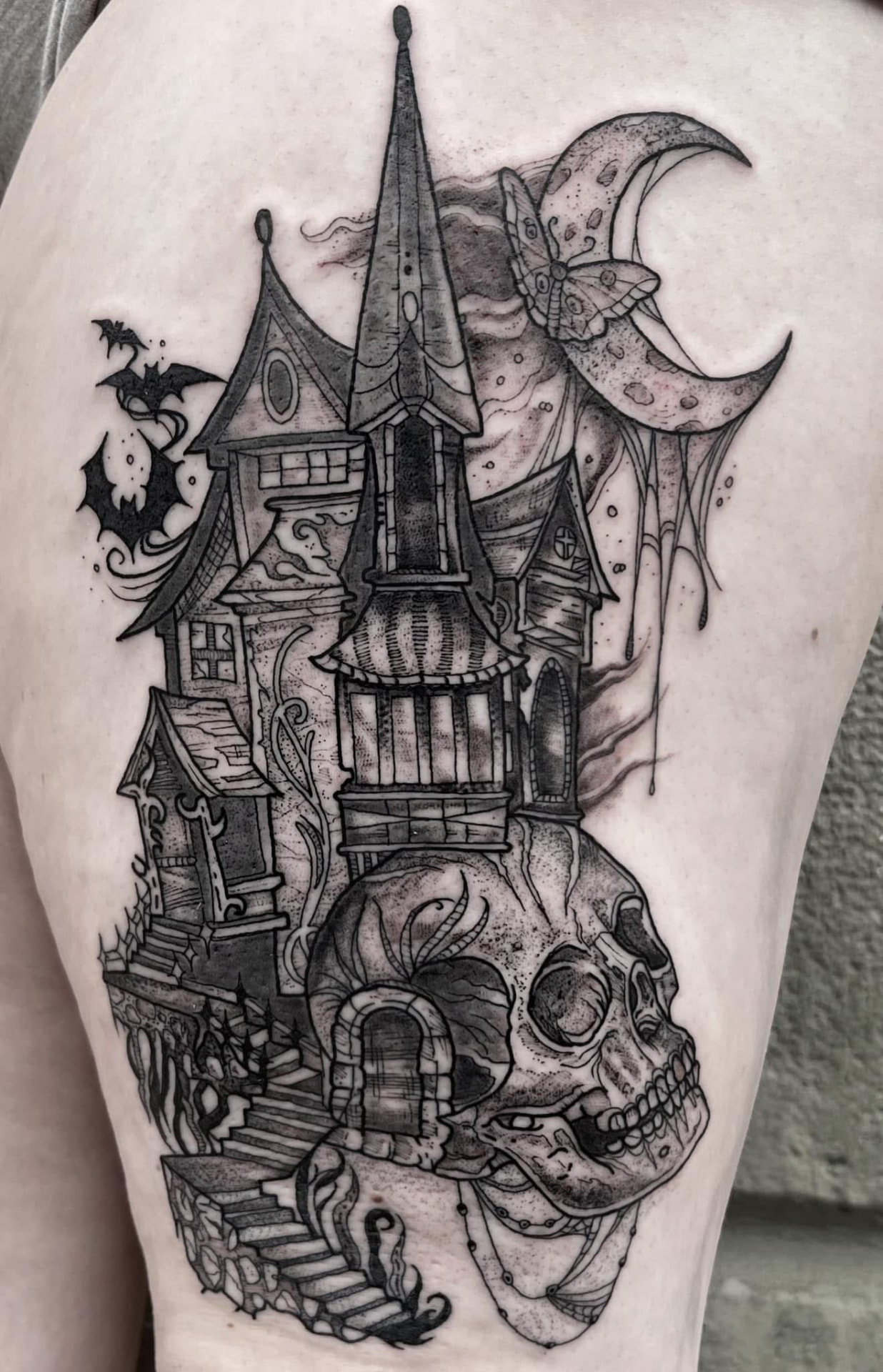 Crooked Victorian haunted mansion built atop a human skull beneath a moth-draped crescent moon