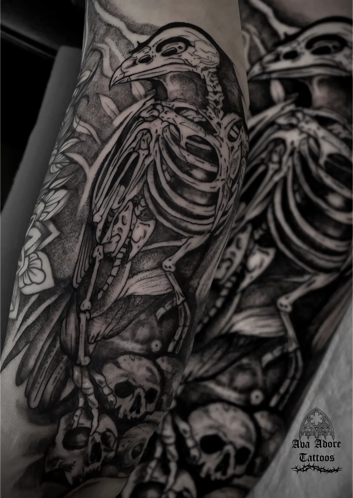 Raven skeleton perched on a pile of human skulls among shaded leaves
