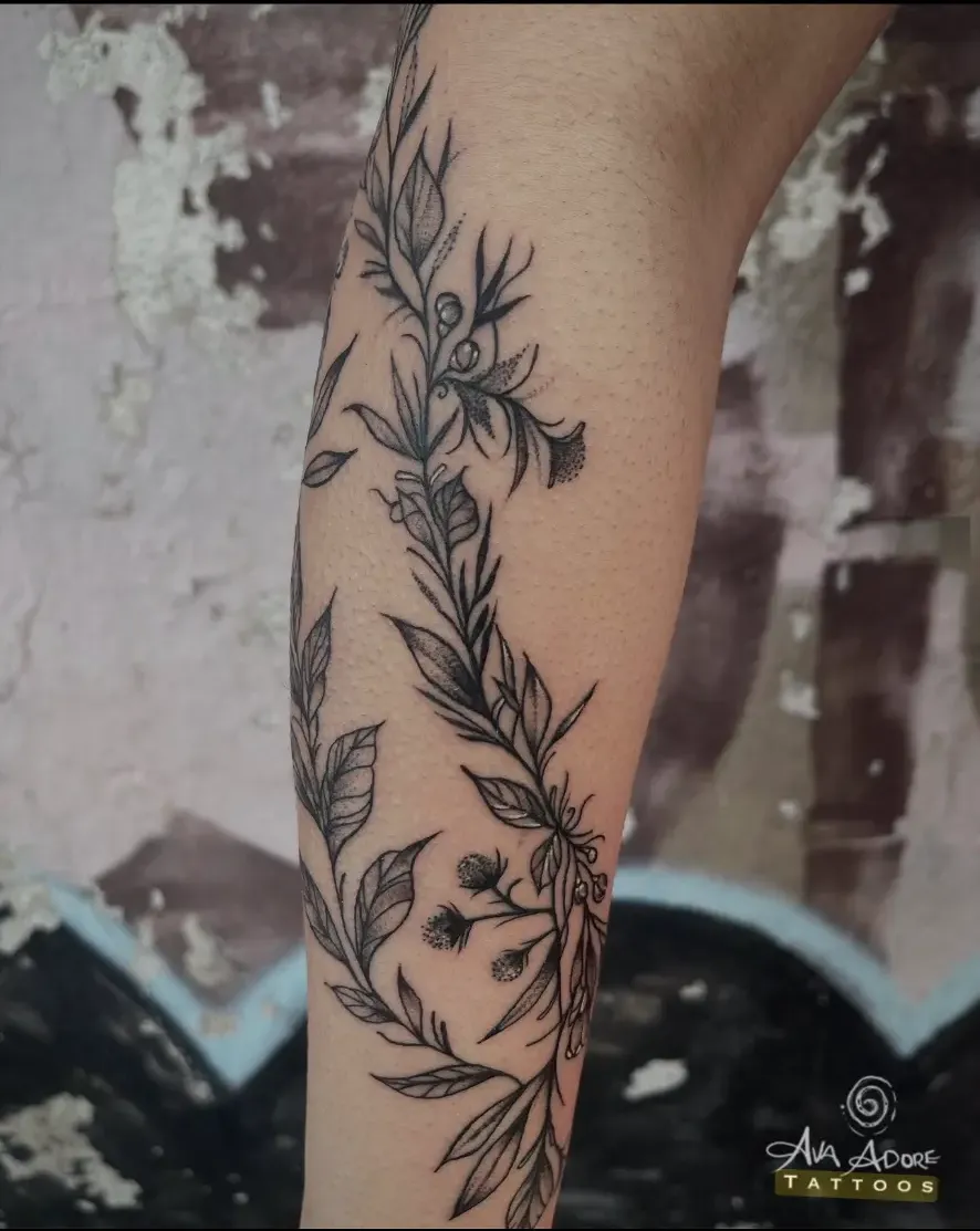 Fine line botanical vine wrapping a forearm with leaves and bell flowers