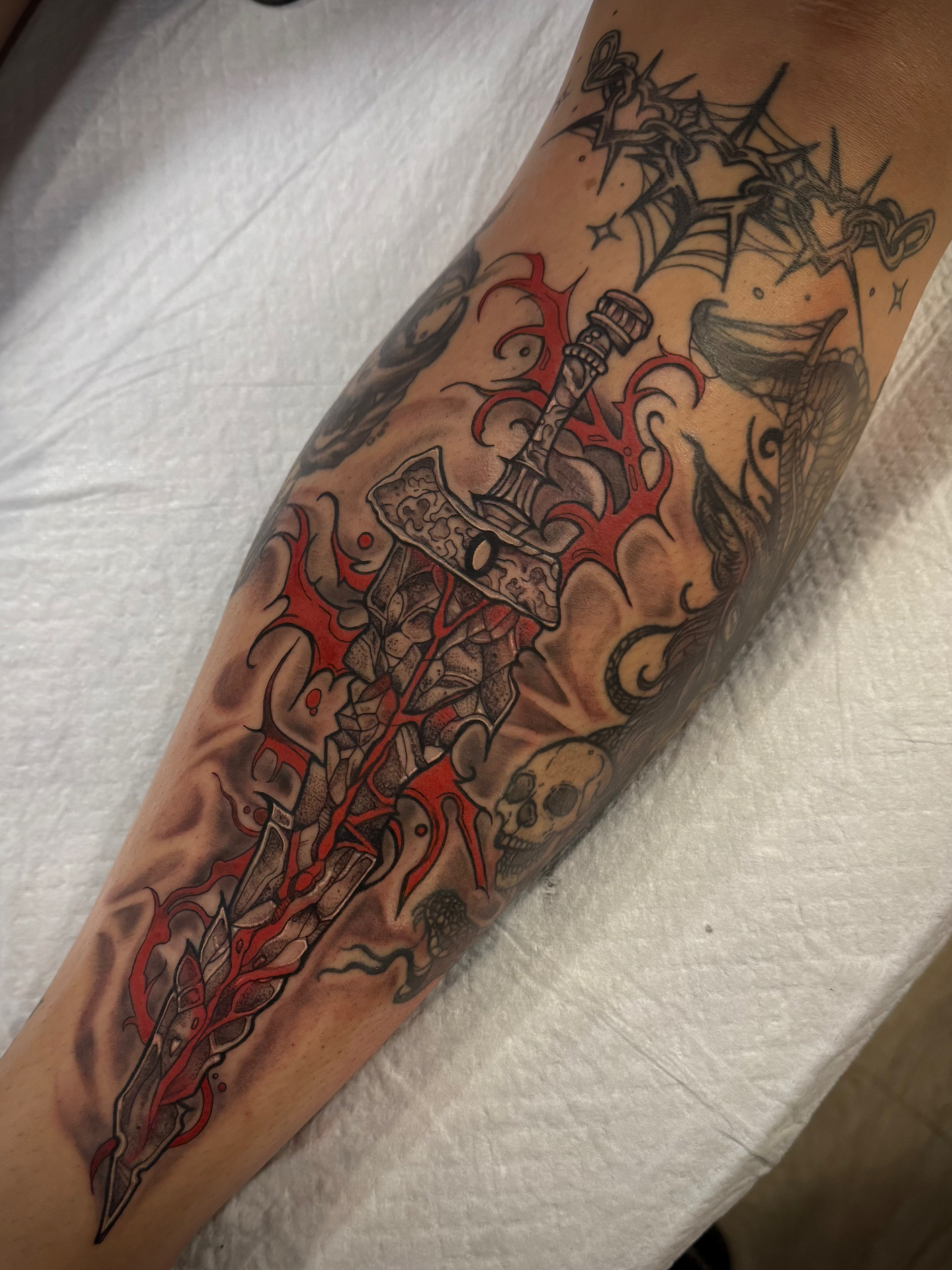 A shattered stone greatsword wrapped in red thorned flourishes, with a skull and serpent.