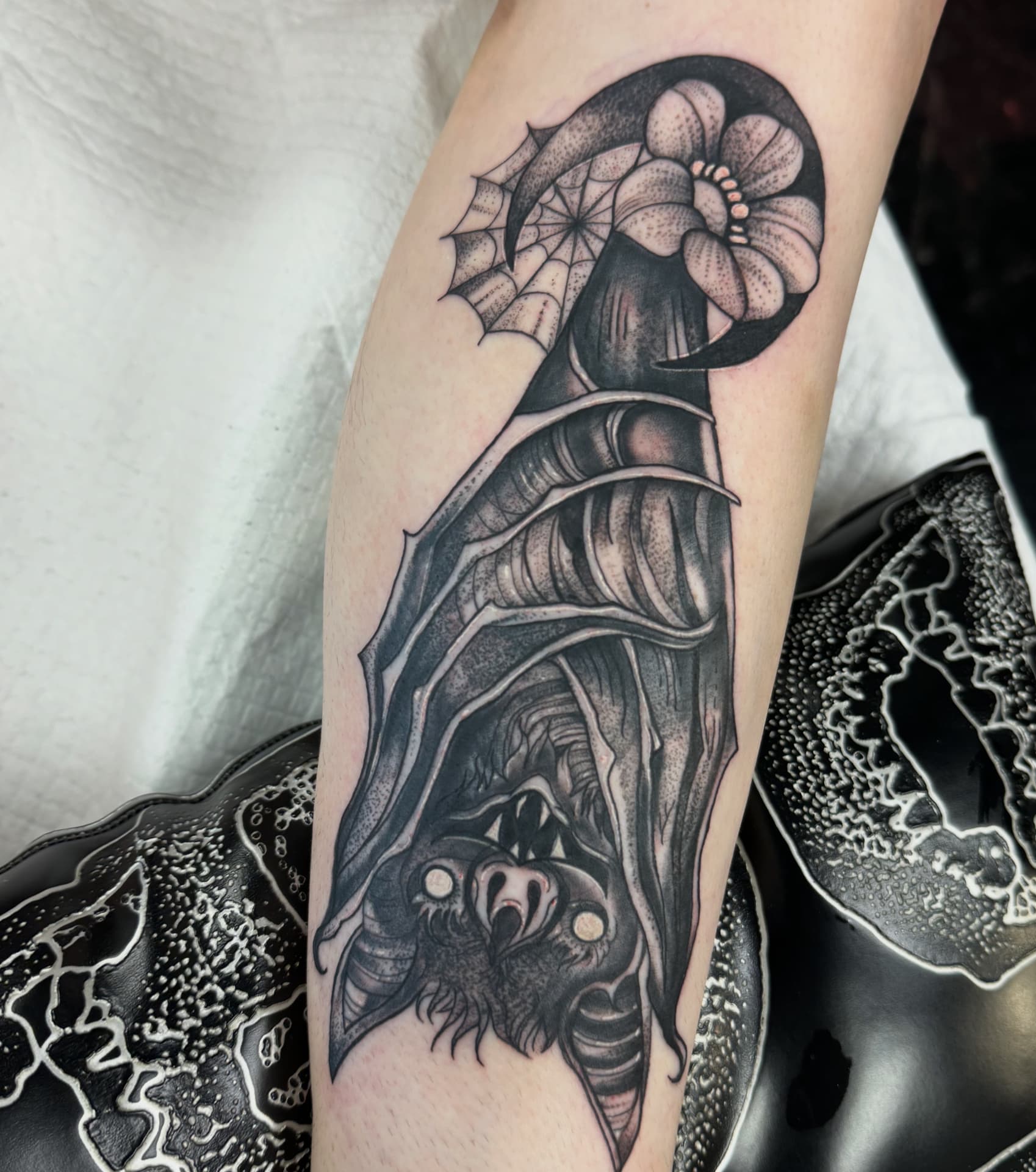 Neo-traditional hanging bat with lily, crescent moon and spiderweb on a calf